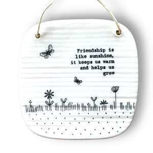 Square porcelain plaque with the words 'Friendship is like sunshine, it keeps us grow' with picture of grass, flowers and butterflies