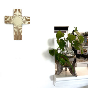 The Elio cross from Coast to Coast with a wooden background and ivory coloured rays makes a statement on the wall