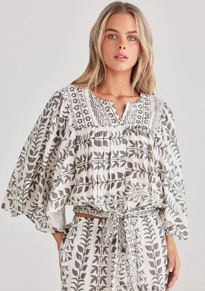 Full flutter sleeves with a tie at the waist, this top in white with grey block prints is designed by Talisman