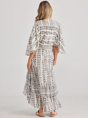 Rear view of the Melrose top with Full flutter sleeves and a tie at the waist, this top in white with grey block prints is designed by Talisman