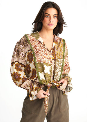 Our Zali shirt in earthy tones has a green fringe trim and tie up front