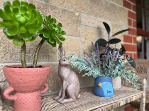 Bird pot on display outdoors with other posts and decor