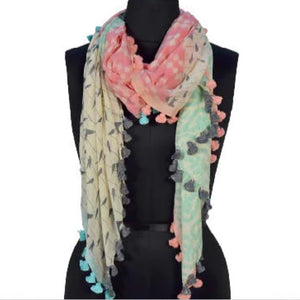 This scarf is coloured white, grey, pink and mint with pom poms to match