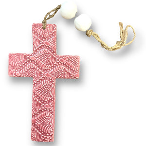 Hand made hanging ceramic wall cross in rose pink with unique intricate pattern imprinted
