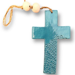 Hand made hanging ceramic wall cross in turquoise with unique intricate pattern imprinted