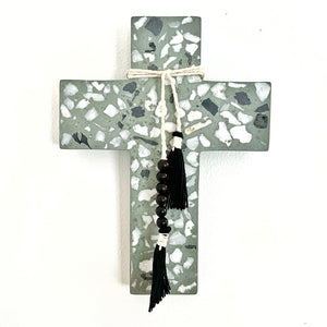 The Bonnie cross is made of terrazzo and is decorated with white string and black beads 